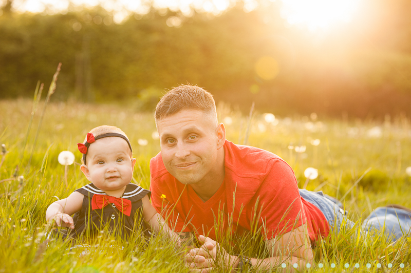 Amazing image of father and daughter laying in the grass during the golden hour