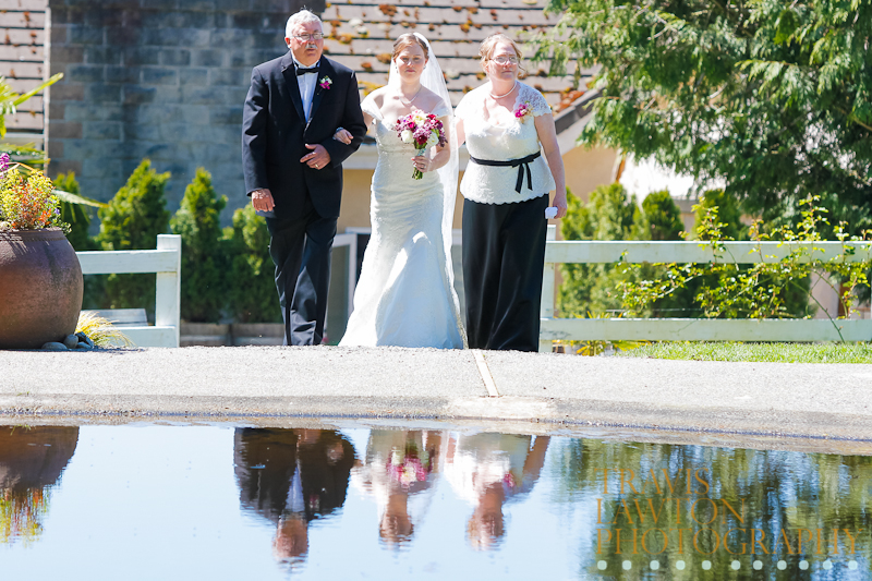 Bride and parents walking with a perfect reflection in the pond