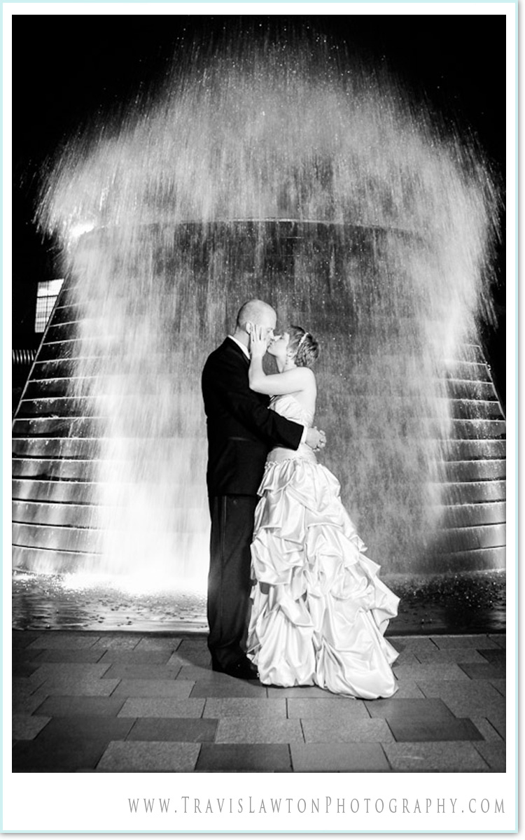 bride and groom kissing in front of a massive water explosion at Fountain park in bremerton washington